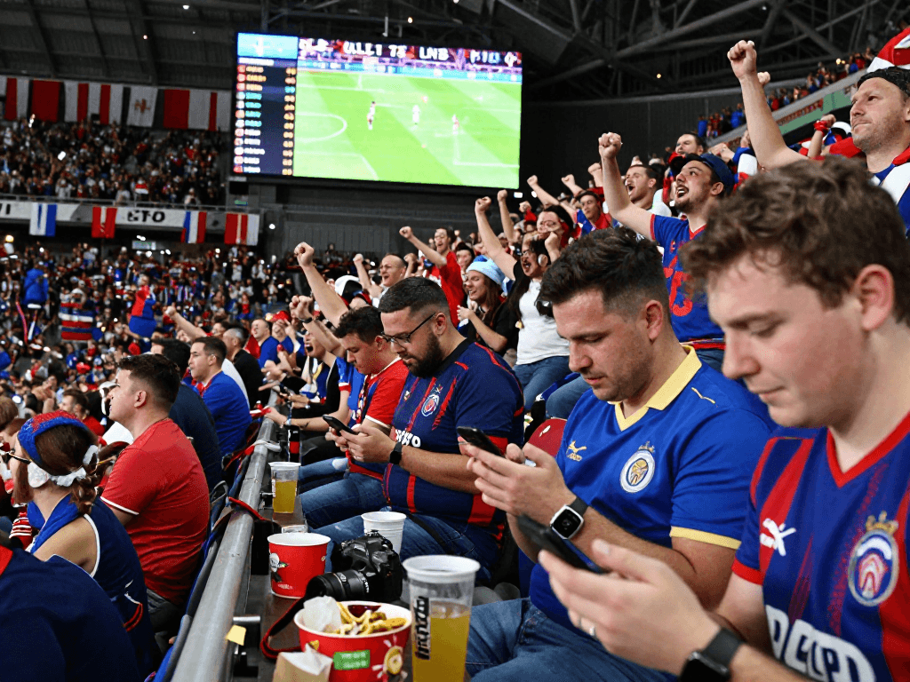 Fussball WM Wettanbieter: Stadionatmosphäre mit jubelnden Fans und Live-Wettquoten.